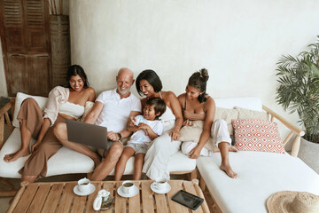 Family With Laptop On Weekend. Happy Interracial Parents With Daughters And Little Boy Using Portable Computer And Having Fun At Home. Mom, Dad, Sisters And Brother On Summer Vacation At Resort.