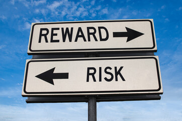 Reward vs risk. White two street signs with arrow on metal pole with word. Directional road. Crossroads Road Sign, Two Arrow. Blue sky background. Two way road sign with text.