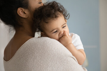 Wall Mural - head shot side back view affectionate caring young mixed race mommy holding on hands little cute sle