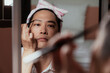 © THESHOTS.CO - Gay concentrate to his eyebrows drawing as a beauty make up.