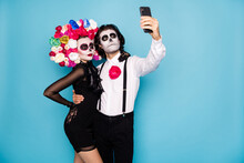 Photo Of Spooky Monster Couple Man Lady Embrace Hold Telephone Make Theme Selfie Picture Wear Short Mini Black Dress Death Costume Roses Headband Suspenders Isolated Blue Color Background