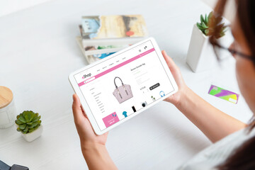 Wall Mural - Girl shopping online with tablet. Modern flat design ecommerce website with woman products on tablet display. Work desk in background