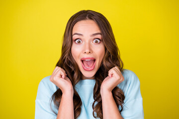 Wall Mural - Photo of lovely pretty funky young girl raise fists open mouth enjoyed look yelling yeah number lottery ticket match win result wear blue pullover isolated vibrant yellow color background