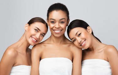 Three Multiracial Women Wrapped In Towels Posing On Gray Background