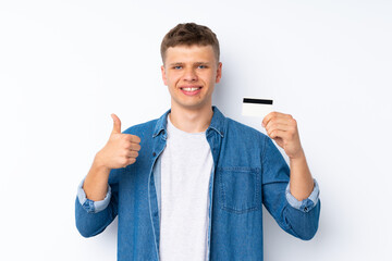 Wall Mural - Young handsome man over isolated white background holding a credit card