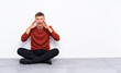 © luismolinero - Young handsome man sitting on the floor shouting with mouth wide open