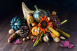 Close up of a cornucopia centrepiece filled with various autumn decorations