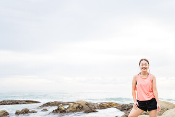 Wall Mural - Running asian woman at the beach in the morning.Female runner jogging during outdoor workout on beach. Beautiful fit asian fitness model outdoors.Healthy lifestyle, Portrait people fitness aerobic.