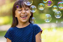 Girl Playing With Soap Bubbles Outdoors
