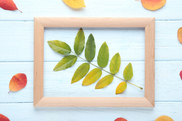 Wall Mural - Autumn leafs with wooden frame on white table