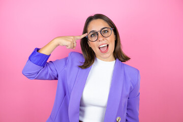 Young beautiful business woman over isolated pink background smiling and thinking with her fingers on her head that she has an idea.