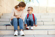 © JenkoAtaman - first day at school. mother and little schoolboy son sit on the stairs together.