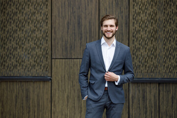 Portrait of smiling stylish young businessman in suit in city