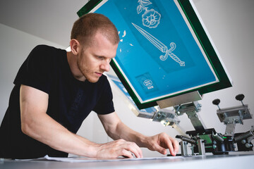 Wall Mural - Selective focus of craftsman working on screen printing press in workshop 