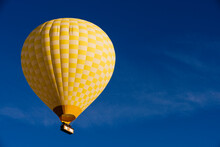 Yellow Hot Air Balloon Floating Against Blue Sky, Goreme National Park, Cappadocia, Anatolia, Turkey