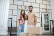 © zinkevych - Young family standing near boxes and smiling