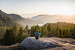 © Connect Images - Man sitting on rock, looking at view, Stawamus Chief, overlooking Howe Sound Bay, Squamish, British Columbia, Canada