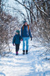 © zhukovvvlad - Woman with a child on a winter hike in the mountains.