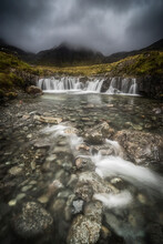 Scenic View Of Fairy Pools Against Cloudy Sky
