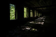 © Dmitriy D - A row of broken Windows in an abandoned industrial building with lush green vegetation outside