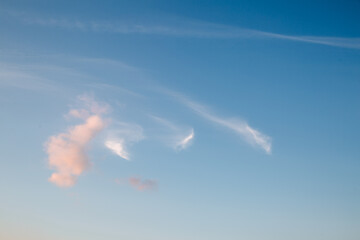 Wall Mural - the clouds in the sky are lit up by the rays of the setting sun.