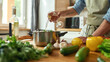 © Svitlana - Cropped shot of man, Italian cook pouring a glass of white wine into the pan with chopped vegetables while preparing a meal in the kitchen