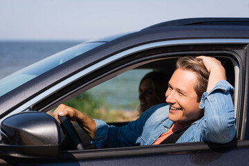 Wall Mural - Selective focus of man driving car near wife during weekend