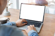 © panitan - computer mockup blank screen.hand woman work using laptop with white background for advertising,contact business search information on desk at coffee shop.marketing and creative design
