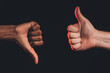 © golubovy - Like dislike gesture. Ethnic diversity. Closeup african male hand thumb down caucasian thumb up isolated on dark. Racial disagreement