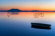 Relaxing and calm sunrise at lake balaton in hungary. Boat and fisher posts. Mountain Badacsonyi and city Badacsony