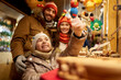 © Syda Productions - family, winter holidays and celebration concept - happy mother, father and little daughter choosing souvenirs at christmas market on town hall square in tallinn, estonia