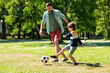 © Syda Productions - family, fatherhood and people concept - happy father and little son with ball playing soccer at summer park