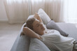 © stokkete - Happy woman lying on the sofa at home and relaxing