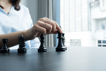 The hands of businesswomen moving chess in chess competitions demonstrate leadership, followers, and strategic plans, business success building processes, and teamwork