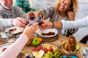 Wall Mural - Family friends have fun together in winter eating food on a wooden table - concept of friendship and caucasian people enjoying celebration at home or restaurant