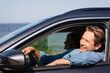 © LIGHTFIELD STUDIOS - Selective focus of man looking away while driving auto near wife