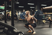 Bodybuilder During His Workout With A Barbell In The Gym