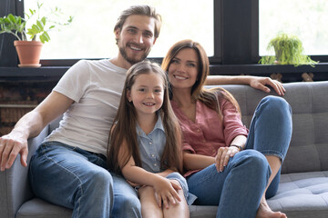 Wall Mural - Cheerful family at home sitting in sofa