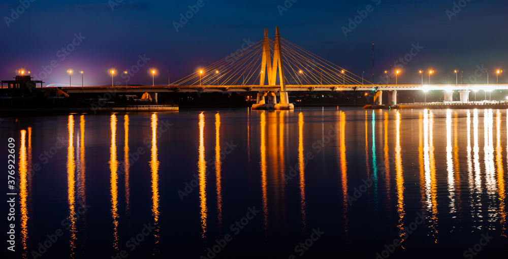 Millenium bridge in Kazan, reflected in the waters of the river Kazanka. Cable-stayed bridge across the river. The bridge with night lighting. - obrazy, fototapety, plakaty 