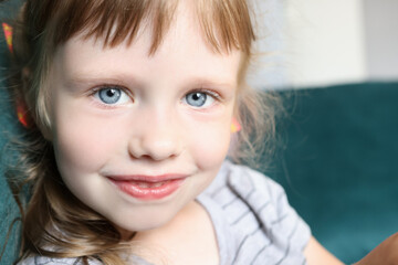 Portrait of little girl with blue eyes and slight smile. Visual examination in children concept