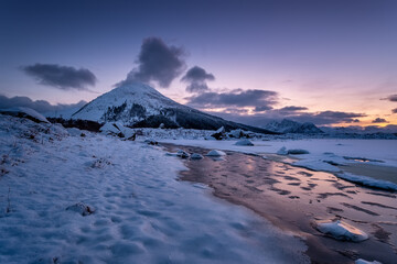 Wall Mural - lofoten islands, norway. mountains, ice with snow and clouds during sunset. evening time. winter lan