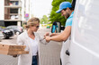 © blackday - Delivery man in a white van delivers pizza to a woman client