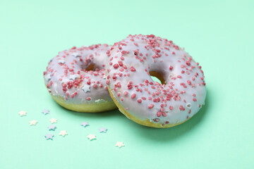 Tasty donuts on mint background, close up