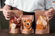 © pressmaster - Close-up of unrecognizable woman presenting packages of sweet dried fruit mixture