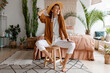 © Svetlana Sokolova - Fashionable image of happy woman in straw hat posing over bohemian interior background. Straw hat , linen  closes. Natural make up. Full lengt.