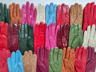 Collection of colored fashionable various leather gloves on a light background.