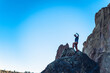 © Cavan Images - Man with arm up on the top of the boulder in Smith Rock park in Oregon