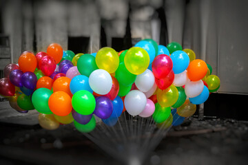 A bunch of colorful gas-filled balloons on dark background.