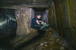© Hennadii - The guy in the underground tunnel inside old sewer shaft