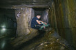 © Hennadii - The guy in the underground tunnel inside old sewer shaft